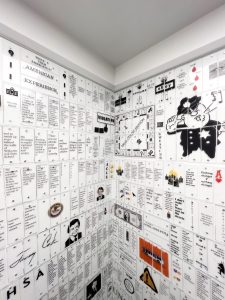 top right corner of the under the microscope booth confessional. it shows a monopoly game board about drug court and go to jail. theres a vintage police officer desperately whistling his whistle